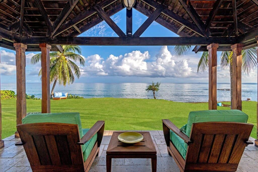 Covered seating luxury villa with a view of the ocean and palm trees in Tryall Club