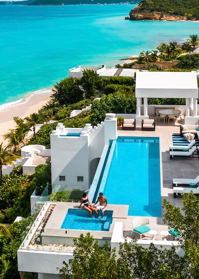 Elevated view of a luxury villa with infinity pool overlooking a turquoise beach in Anguilla
